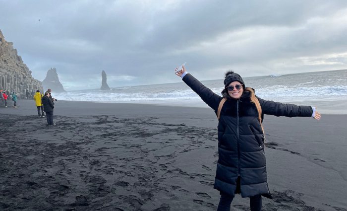 happy woman standing on reynisfjara beach