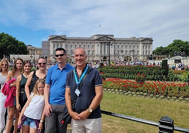 people posing in front of buckingham palace