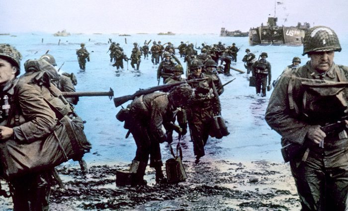 soldiers walking onto beach at normandy