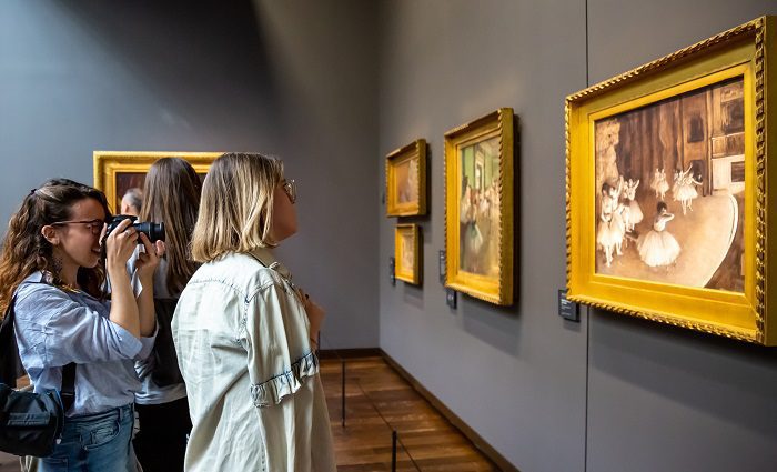 Visitors standing in front of artwork on a Musee d'Orsay guided tour in Paris