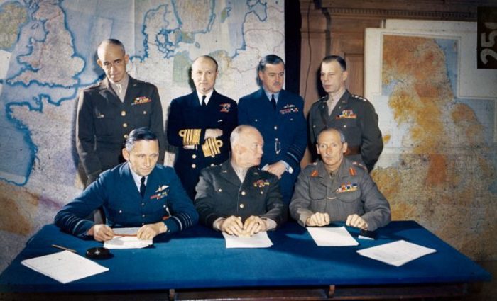 british and american generals meeting in front of a map