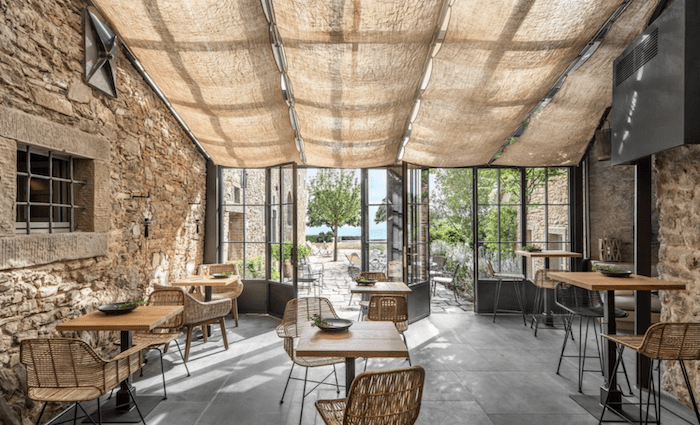 The stylish dining area with exposed stone walls and burlap blinds in Arezzo.