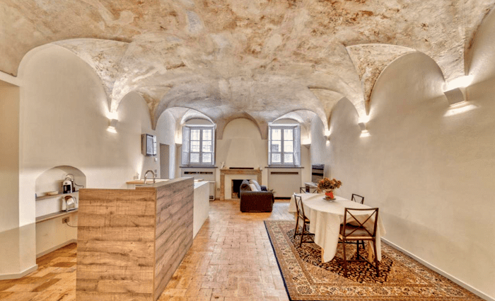 The main room of the apartment. Painted muted cream tones, with a terracotta floor and a vaulted stone ceiling.