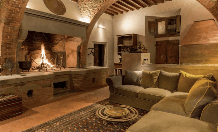 The living room with an open fire in the traditional townhouse in Arezzo.