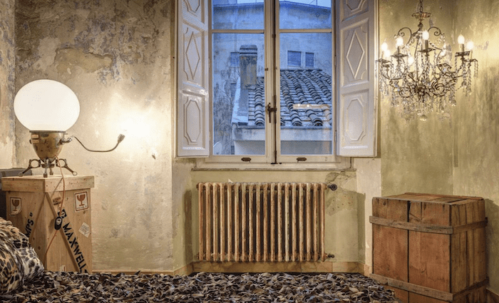 The raw chic bedroom with a view out the window over the terracotta roof tiles in Arezzo.