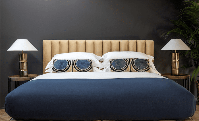 The bedroom with luxe finishes and an art deco vibe in hues of blue and gold. 