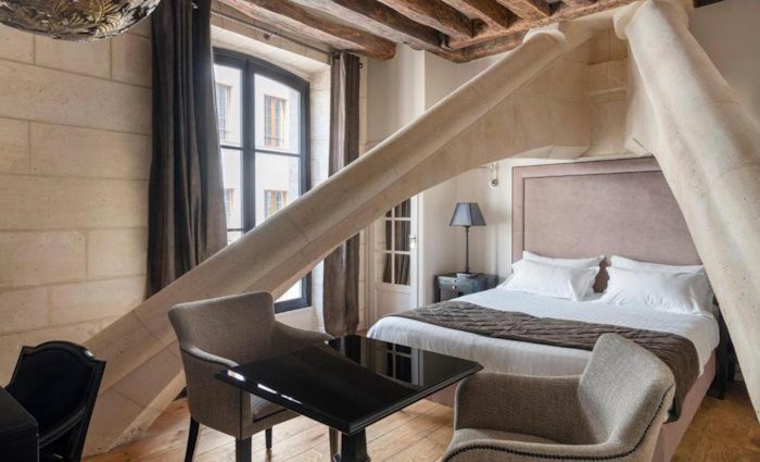 inside bedroom with flying buttresses above the bed