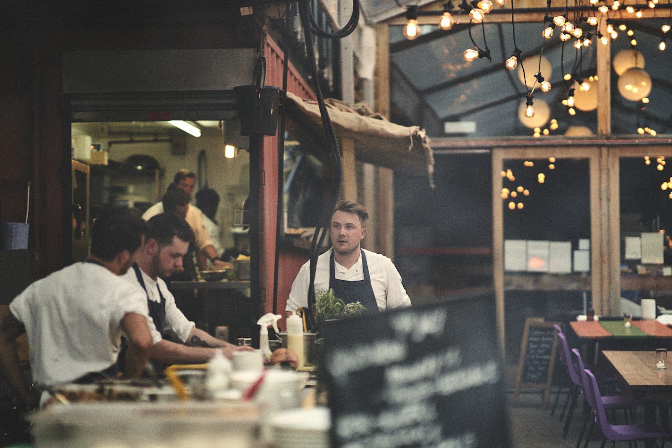 Chefs cooking in a dimly lit kitchen.