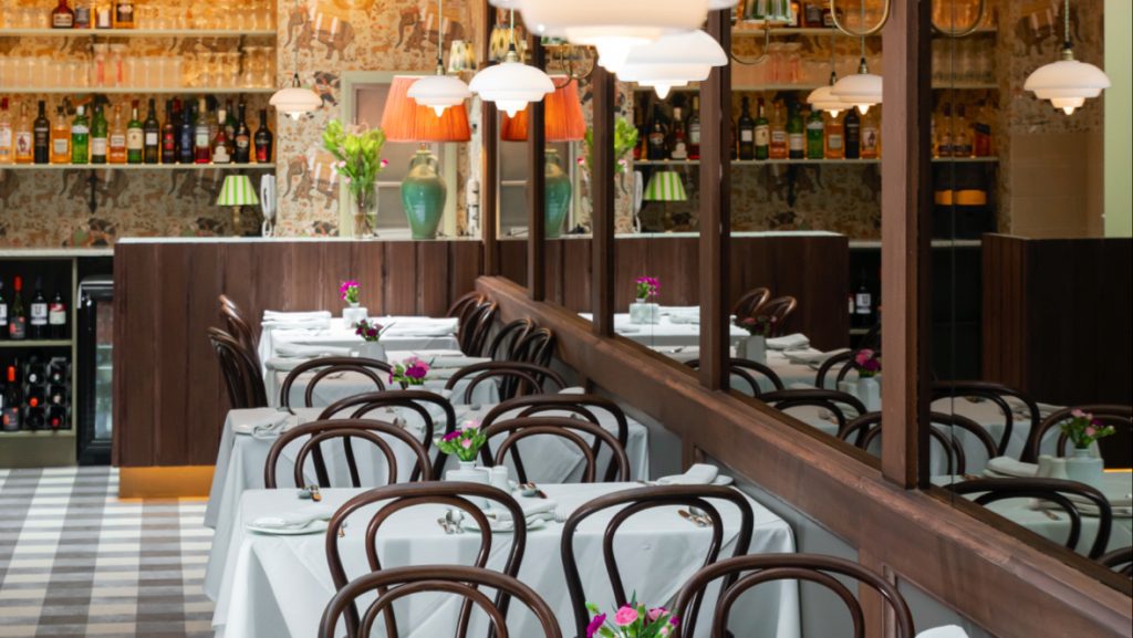 Bentwood chairs next to tables with white linens at Little India restaurant in London.