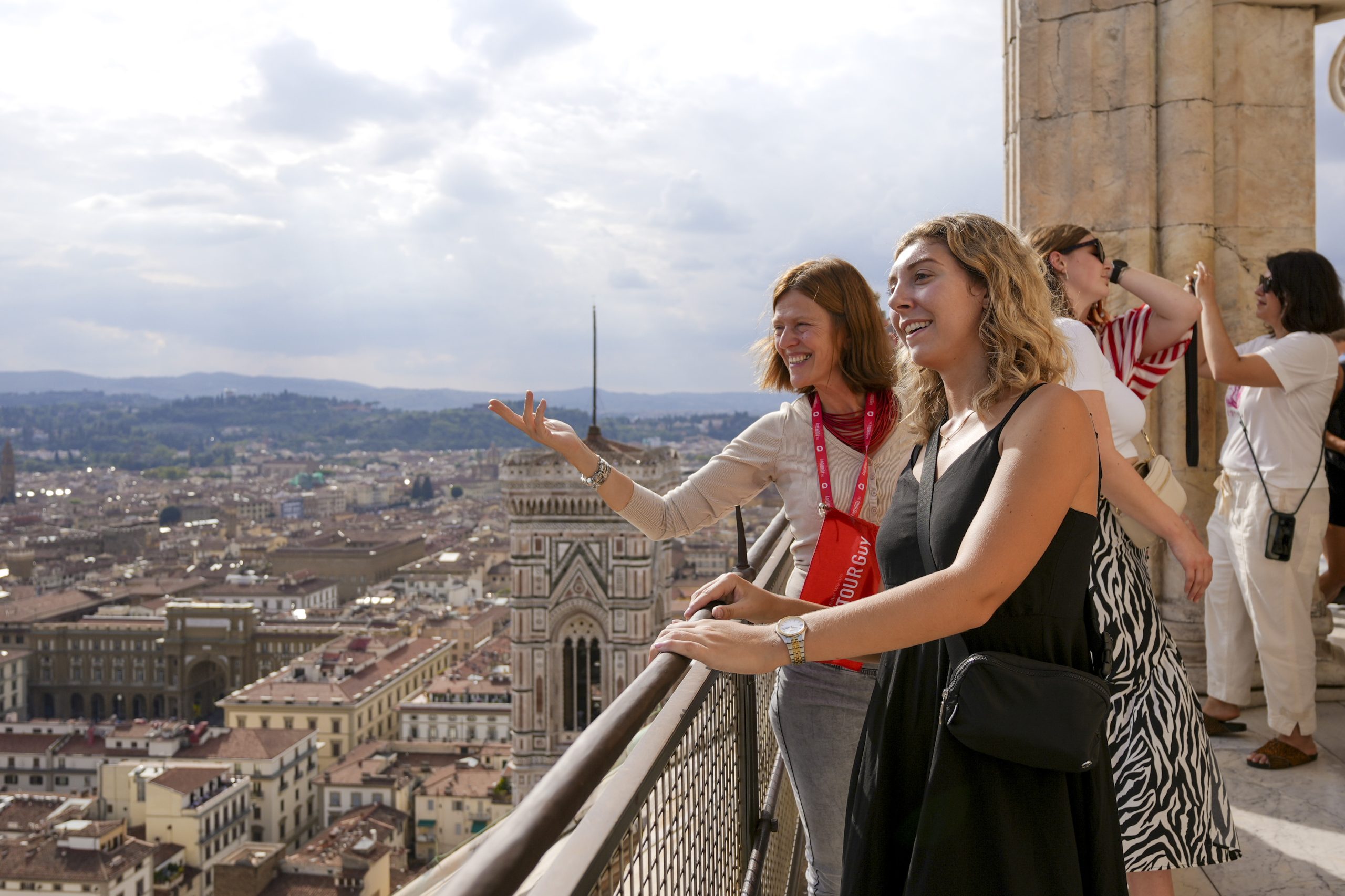 A woman on top of Florence's Dome looking out to the city with her guide from The Tour Guy.