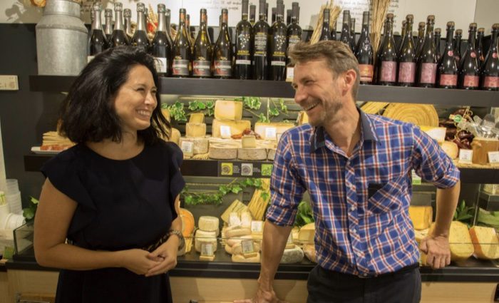 two people laughing in a cheese shop on one of our food tours of Paris