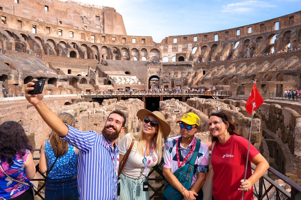 Tour group taking a selfie picture inside the Colosseum in Rome, Italy