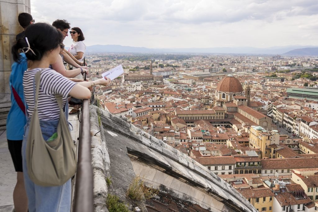 Tourists on top of the Florence Duomo looking out over the city.