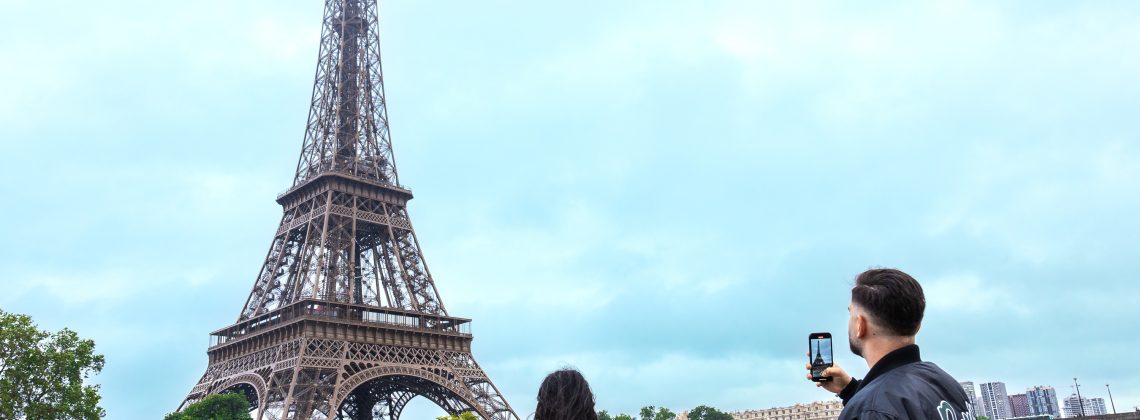 Two people taking photos of the Eiffel tower in paris