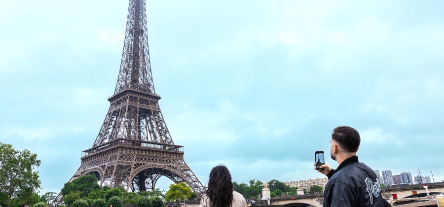 Two people taking photos of the Eiffel tower in paris