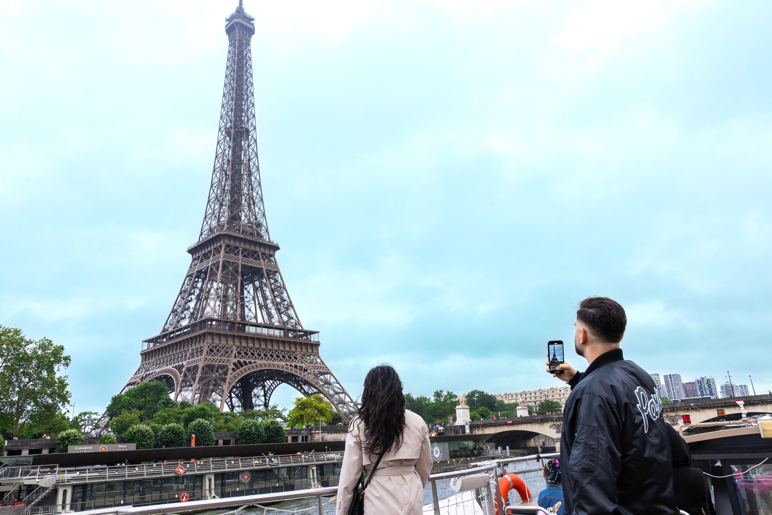 Two people taking photos of the Eiffel tower in paris