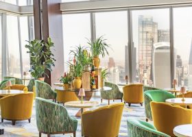 Colorful chairs in a bar overlooking the London skyline.