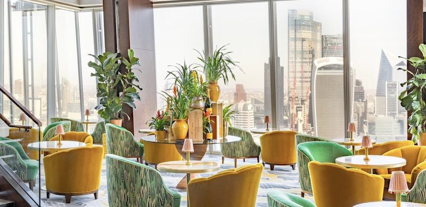 Colorful chairs in a bar overlooking the London skyline.