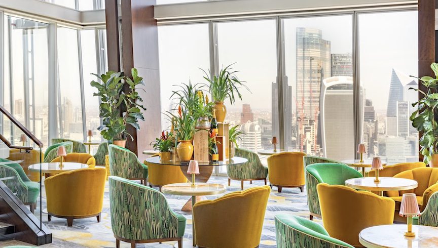 Colorful chairs in a bar overlooking the London skyline.