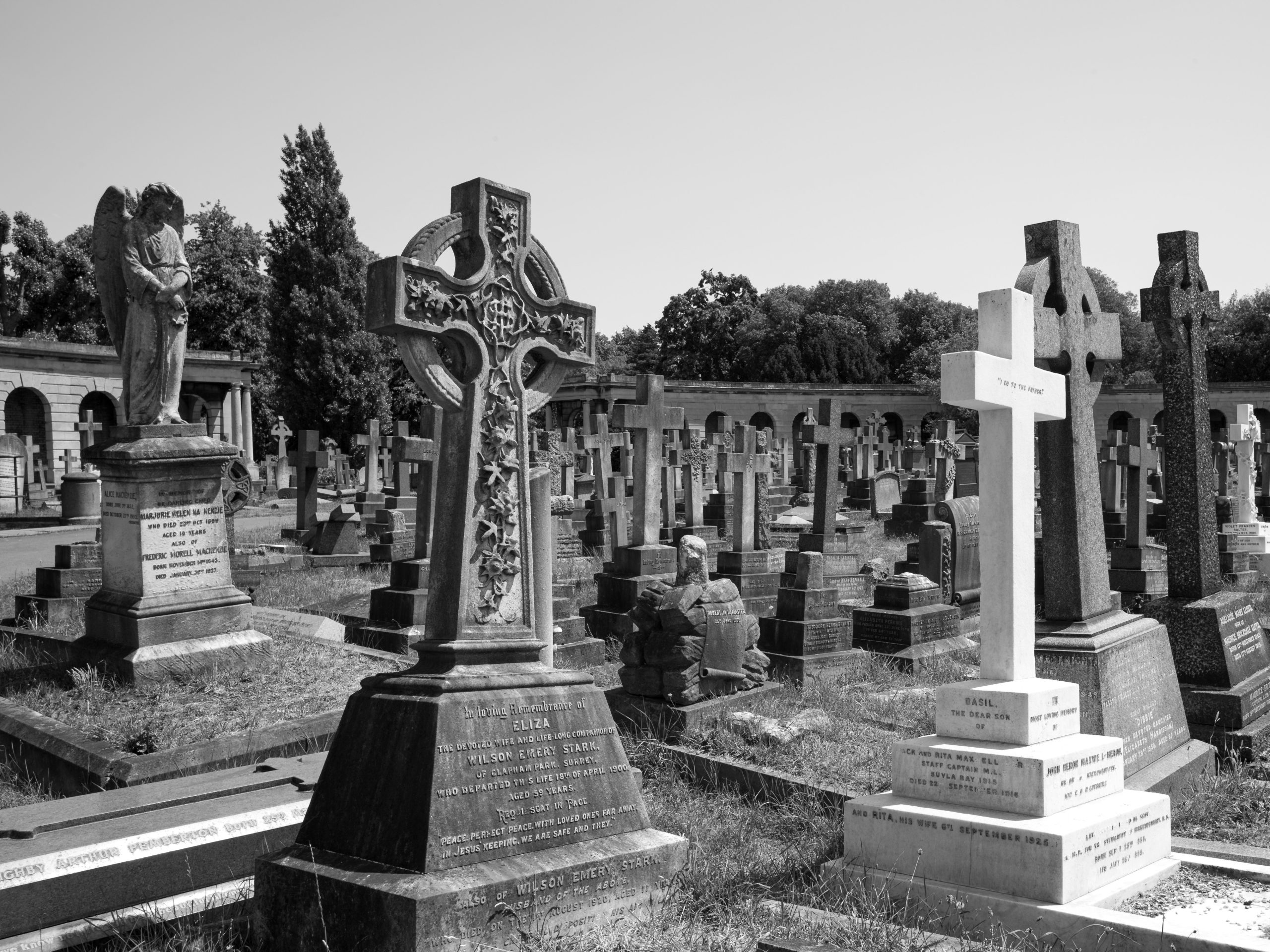 Large stone crosses on top of gravestones in a cemetery. 