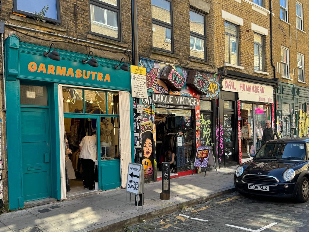 Teal blue sign with yellow font that reads "Garmasutra"