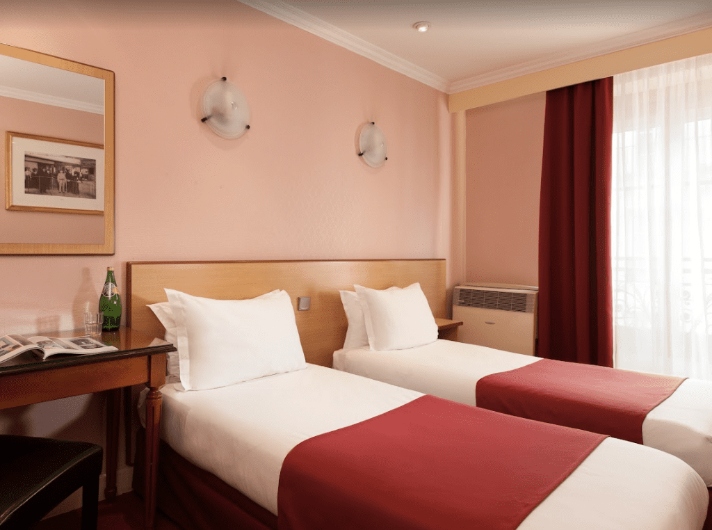 Pink walls with white beds and red blankets.