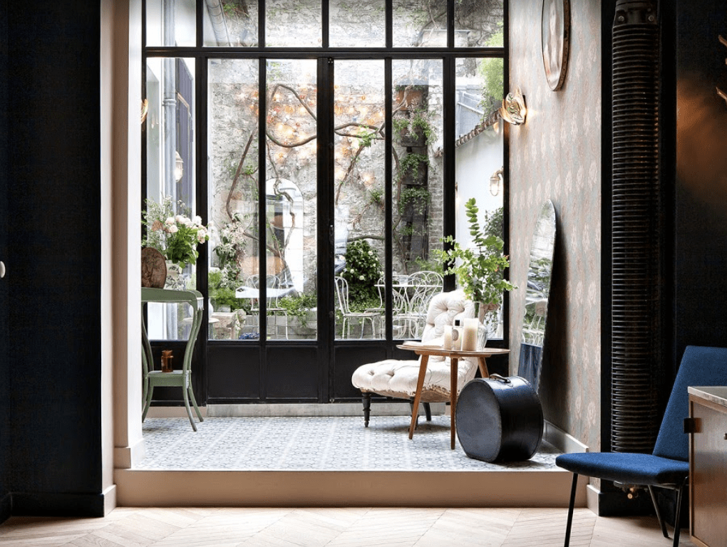 A window overlooking a garden with lots of flowers and trees.