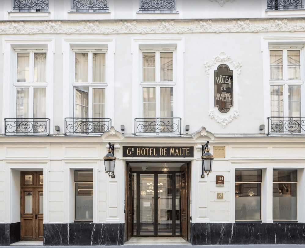 White building with black iron balcony fences.