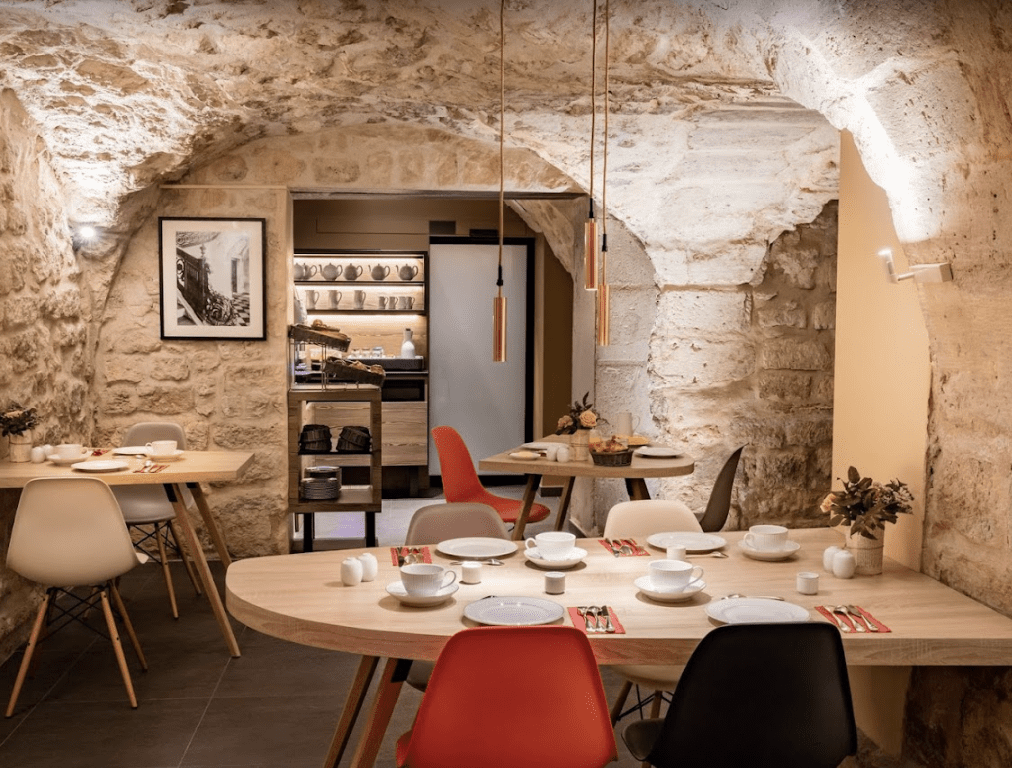 Brick cellar with vibrant red chairs