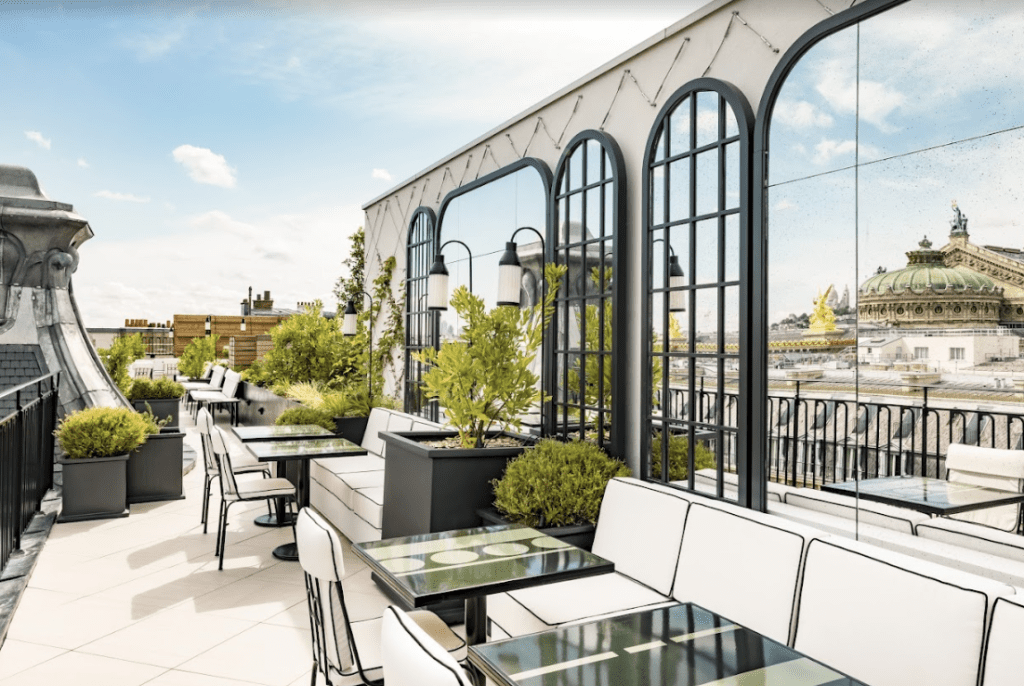 White chairs on a sunny rooftop restaurant.