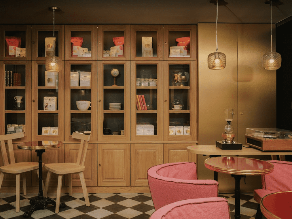 Light wood plate shelf with pink chairs.