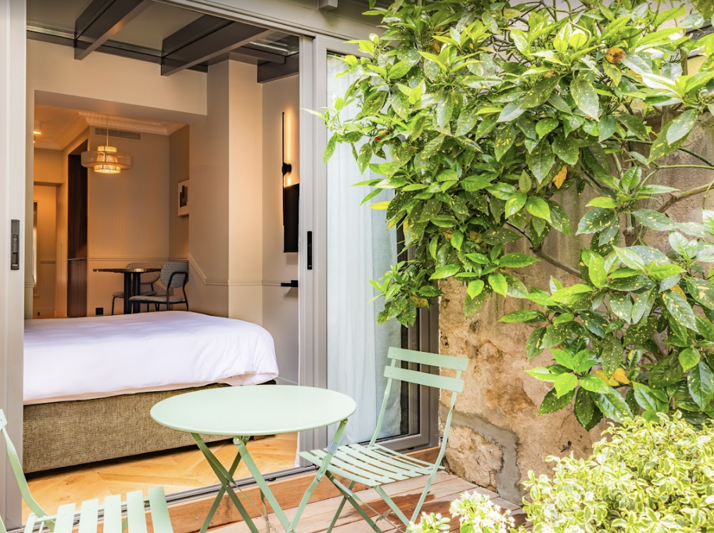 A bed over looking a terrace with a tree.