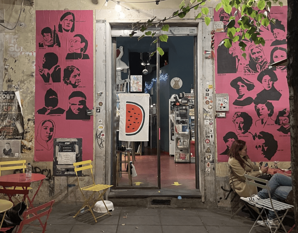 Pink murals with images of faces painted on a wall.