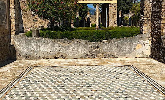 The remains of the wall and floor with mosaics of the House of the Tragic Poet in the Pompeii Archaeological Park.