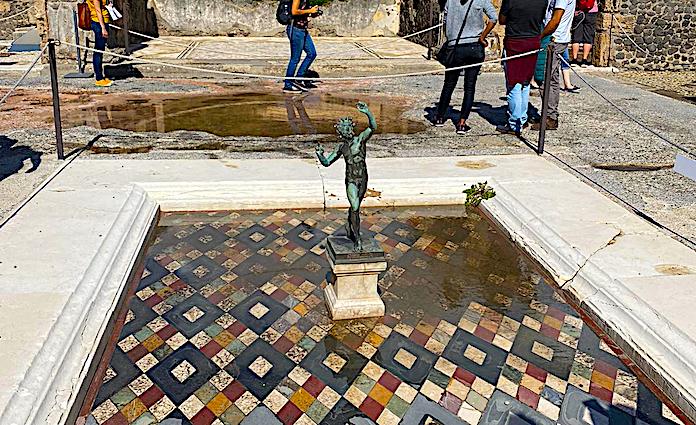 Statue of a fuan in a water feature at the house of the faun in the Pompeii Archaeological Park.
