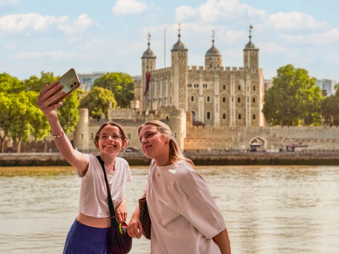 2 young adults taking a selfie with the Tower of London